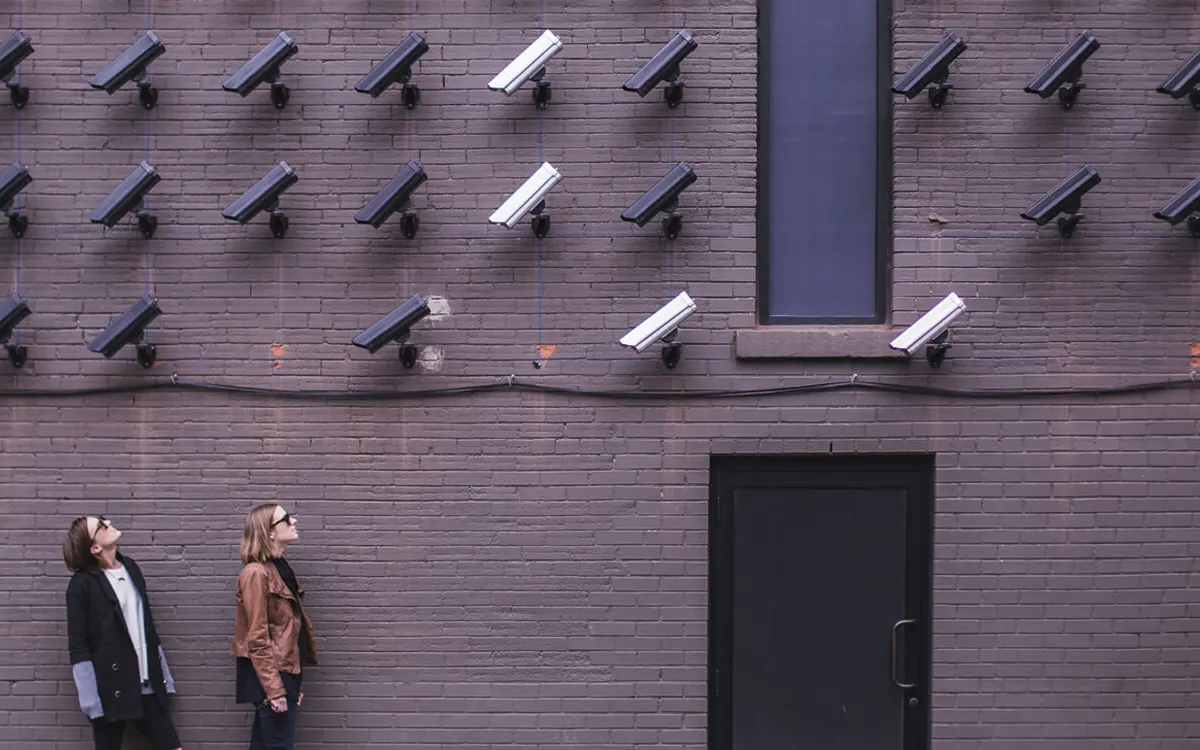 A wall covered in CCTV cameras